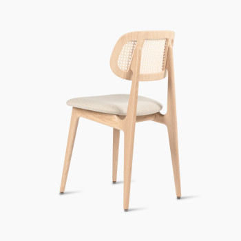 Titus dining chair in natural varnished oak with a rattan backrest and lime white bouclé upholstered seat, rear three-quarter view.