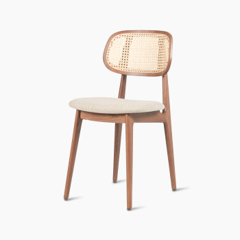 Titus dining chair in tobacco-stained beech with a rattan backrest and lime white bouclé upholstered seat, angled side view.