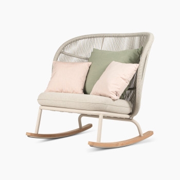 Fauteuil à bascule Kodo en blanc Dune avec siège amande et coussins décoratifs en vert olive et blush par Vincent Sheppard, vue à 45 degrés.