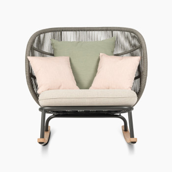 Kodo rocking chair in fossil grey with almond seat and decorative cushions in olive green and blush by Vincent Sheppard, front view.