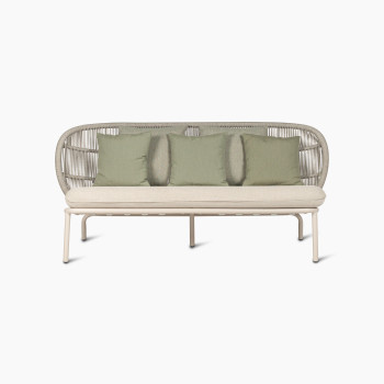 Kodo lounge sofa in Dune white with almond seat cushion and decorative cushions in olive green and blush by Vincent Sheppard, front view.