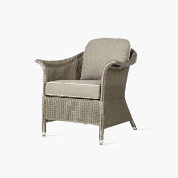 Fauteuil lounge Victor de Vincent Sheppard avec tressage Lloyd Loom et coussins beiges, conçu pour une utilisation intérieure.