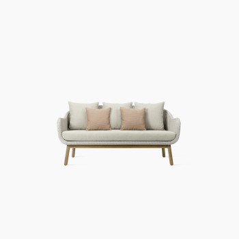 Anton lounge sofa in old lace colour by Vincent Sheppard, featuring a woven Paper Loom frame, natural wood base, with three beige cushions and two coral accent cushions.