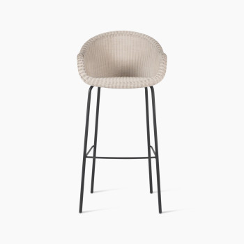 Front view of the Edgard barstool by Vincent Sheppard, featuring an old lace-coloured wicker seat and a black steel base.