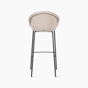 Back view of the Edgard barstool by Vincent Sheppard, featuring an old lace-coloured wicker seat and a black steel base.