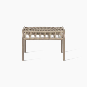 Front view of the Loop footrest in taupe by Vincent Sheppard, featuring a curved metal frame with a tightly woven Lloyd Loom surface designed for foot support.