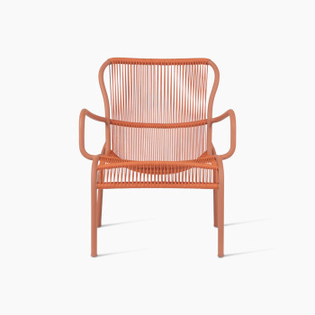 Front view of the Loop lounge chair in terracotta colour by Vincent Sheppard, featuring a curved metal frame and tightly woven synthetic rope for the seat and backrest, offering a bold and modern design.