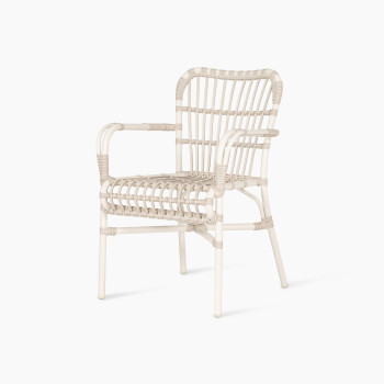 Vue à 45 degrés du fauteuil de salle à manger Lucy en blanc cassé par Vincent Sheppard, avec un cadre incurvé et un design en osier synthétique tissé sans coussin, offrant un style léger et élégant.