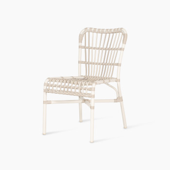 Side view of the Lucy dining chair by Vincent Sheppard, made of synthetic wicker in off-white colour with a woven design and no cushion.