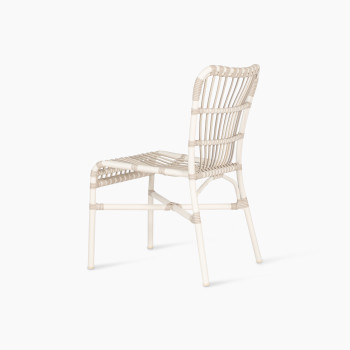 Back angled view of the Lucy dining chair by Vincent Sheppard, made of synthetic wicker in off-white colour with a woven design and no cushion.