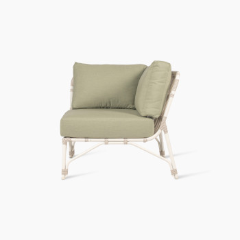 Corner piece of the Lucy modular sofa with green cushions, shown from the front view. The frame features white wicker with subtle curves.