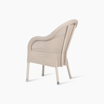 Mia dining chair in old lace colour, shown from a rear side angle. The chair features a wicker frame with a rounded backrest and gently curved design, highlighting its elegant silhouette.