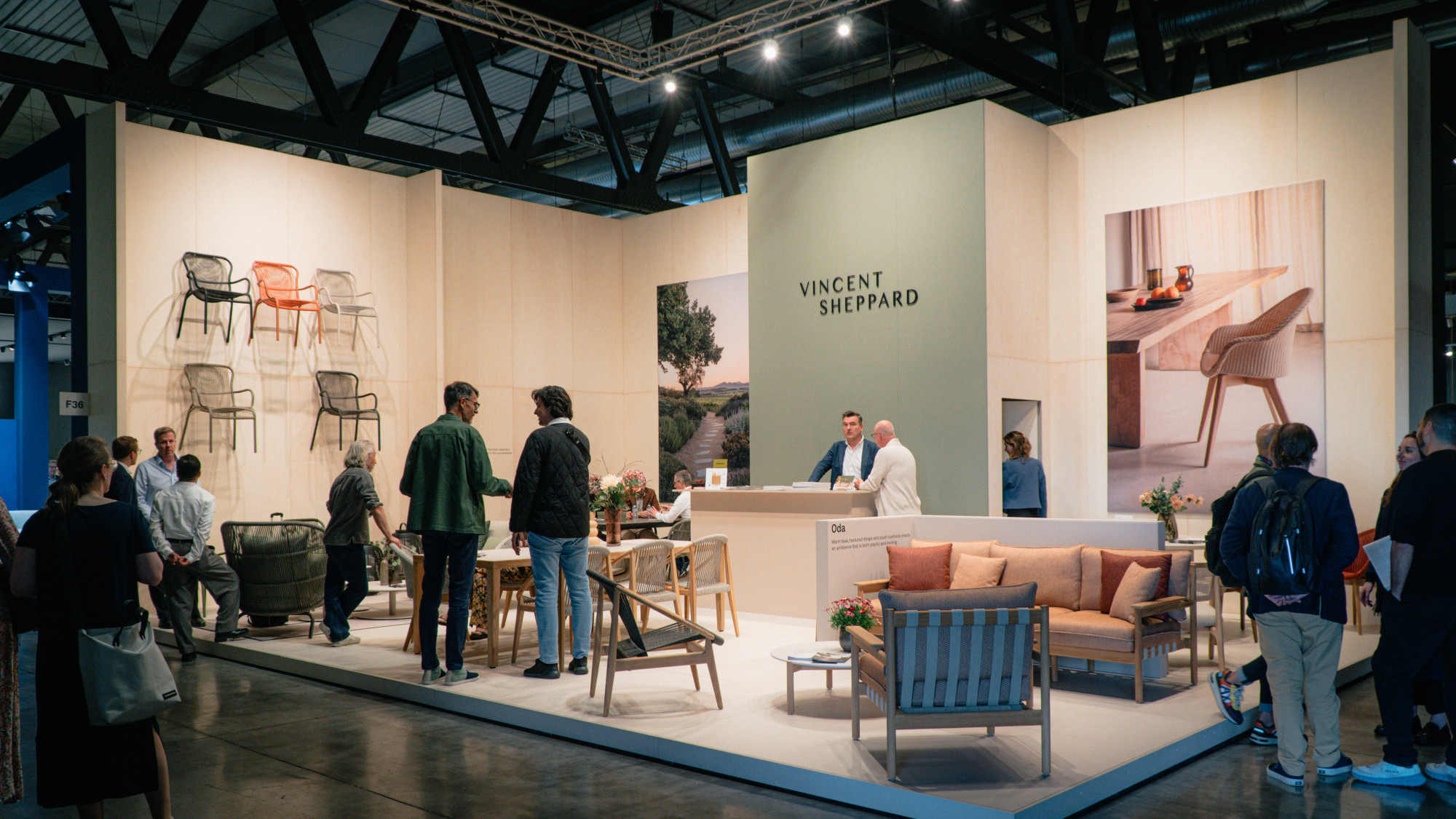 Stand d'exposition de Vincent Sheppard au Salone del Mobile 2024, présentant des chaises en Lloyd Loom contemporaines, des canapés avec des coussins roses doux et un design minimaliste.