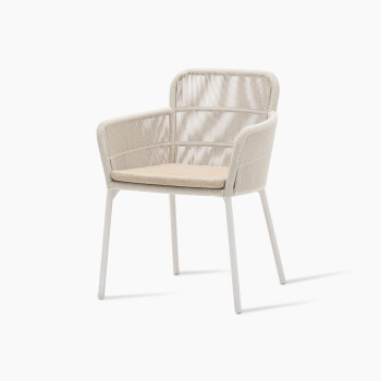 Vincent Sheppard’s Akari dining chair shown at a 45-degree angle, featuring a lightweight aluminum frame, rope-woven back and seat in dune white, paired with a Santal-coloured seat cushion.