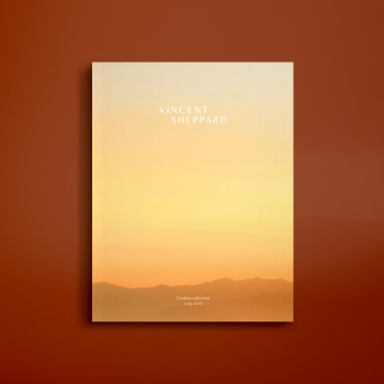 Vincent Sheppard Outdoor Collection 2025-2026 catalog with a gradient sunset cover design, placed against a warm brown background.