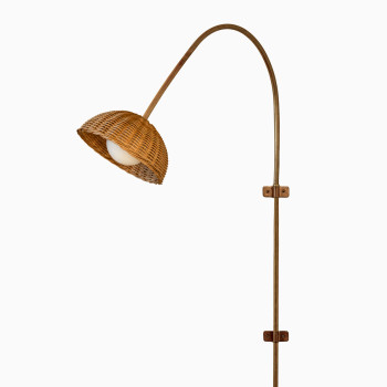 Arvin wandlamp van Vincent Sheppard, met een rotan kap en een messing buis voor een elegante, natuurlijke uitstraling.