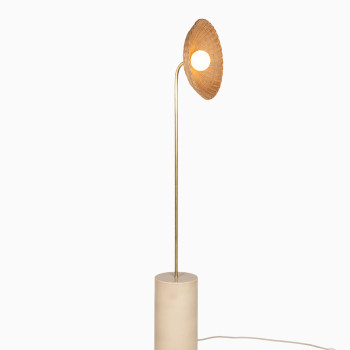 Arvin floor lamp with a curved brass stem, mushroom-coloured ceramic base, and a rattan shade, casting a warm glow.