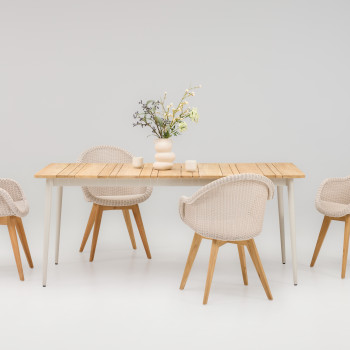 Vincent Sheppard Edgard dining chairs in old lace with woven seats and wooden legs, paired with the Max dining table in dune white with a teak top, styled with a decorative vase and candles.